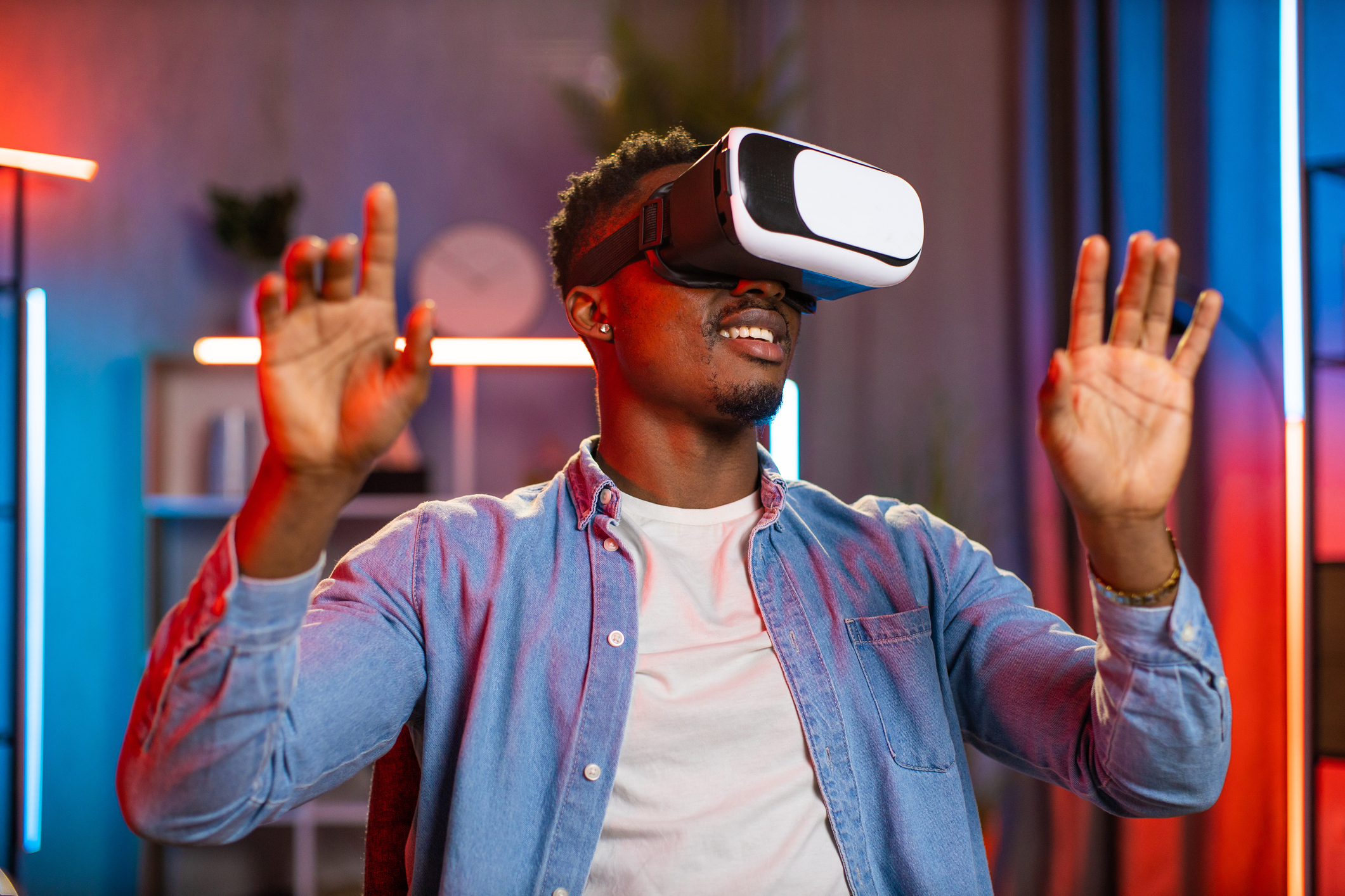 A young man wearing a headset and playing a virtual reality game.